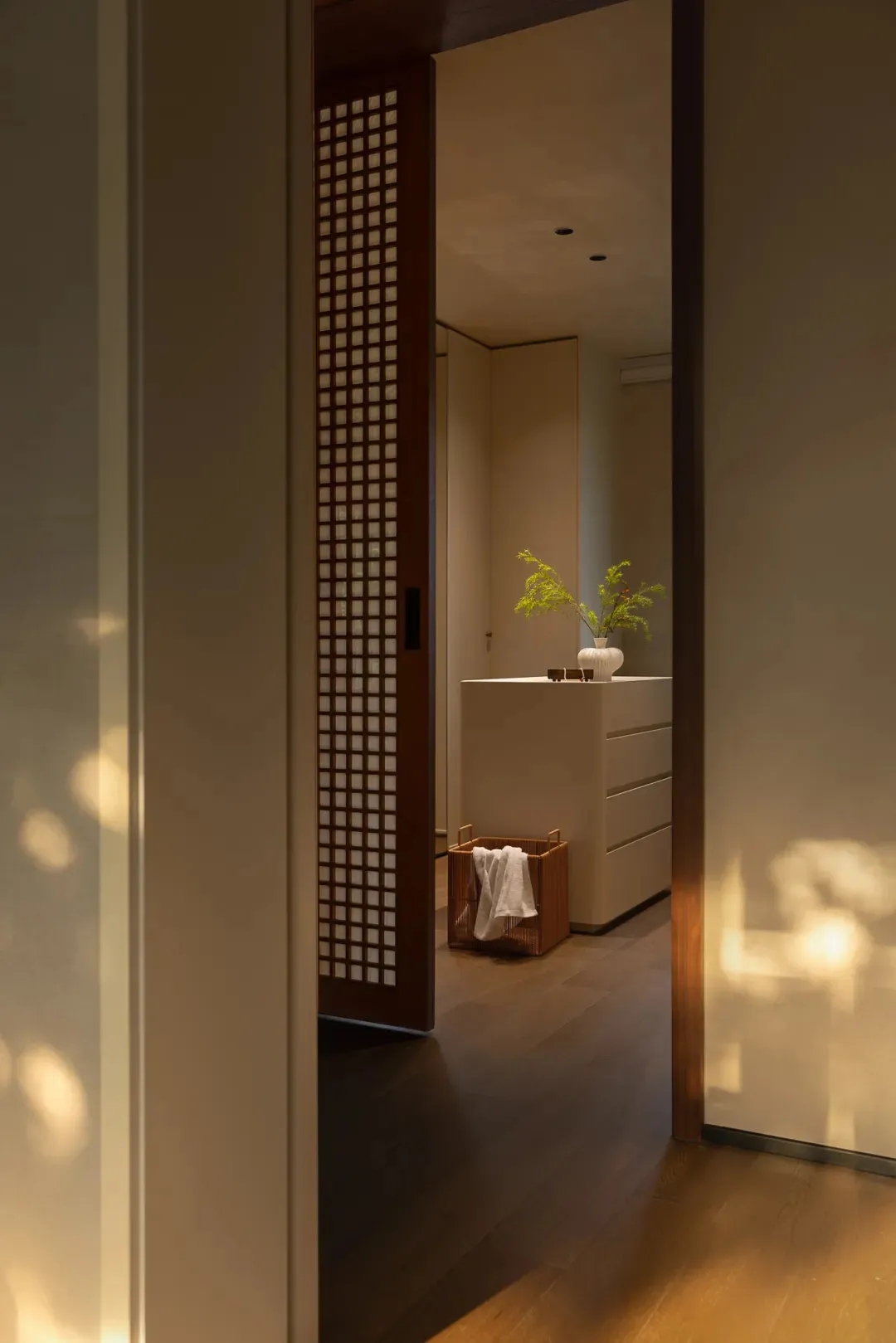 Narrow hallway with wooden flooring and walls, featuring potted plants and a decorative vase, giving a warm and traditional feel