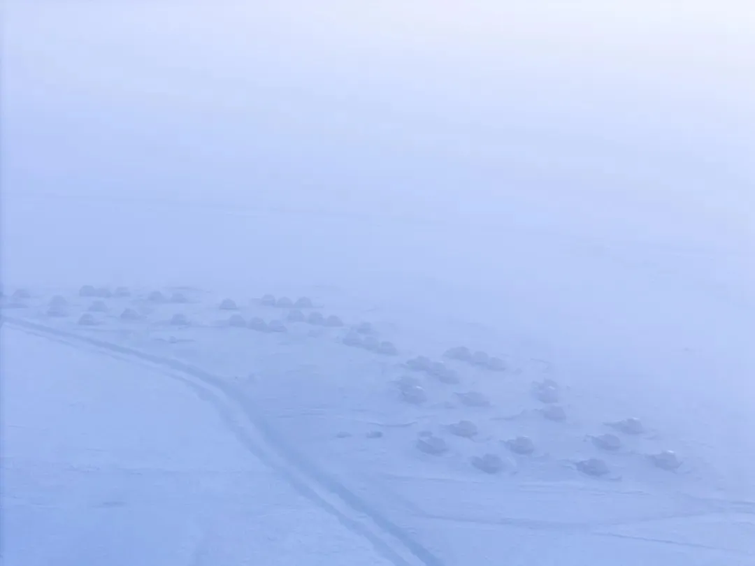 一排的小木屋，覆蓋著雪的廣闊冬天景象