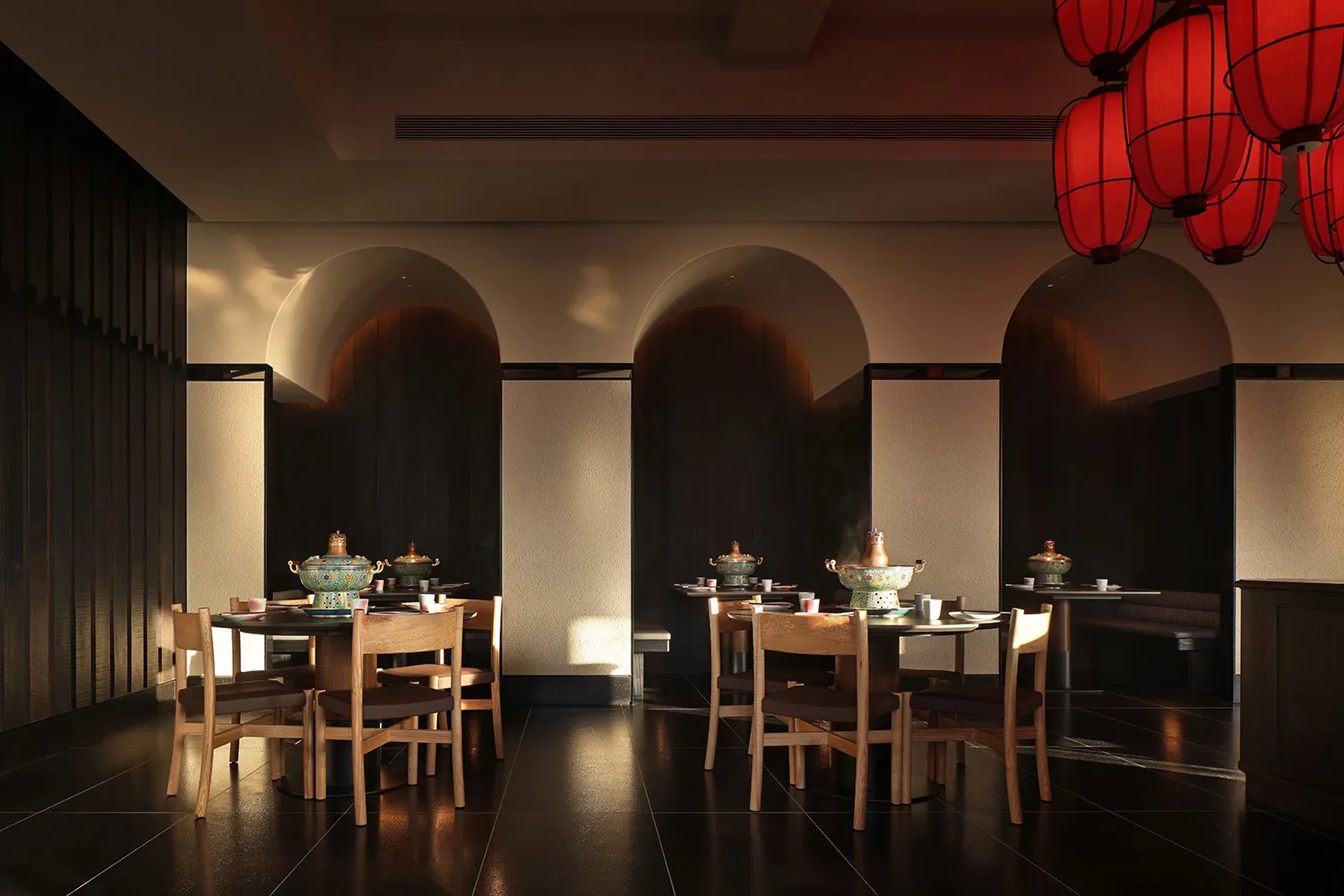 A modern restaurant with a dining area featuring a long table and chairs, and a kitchen with an oven and sink, set against a predominantly white background with dim lighting