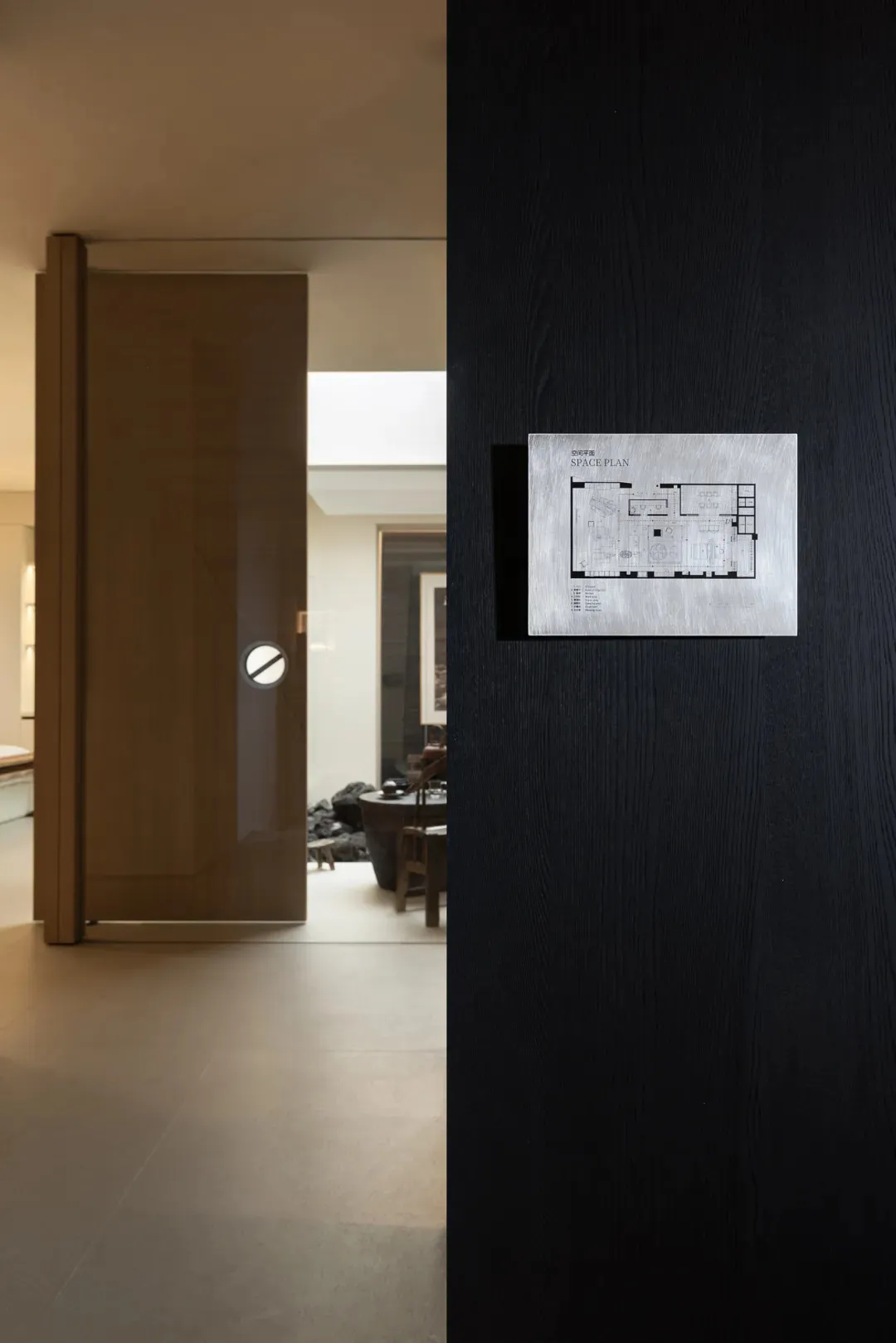 2D floor plan of a cozy living room with a wooden door, chair, and couch, featuring natural lighting and neutral tones