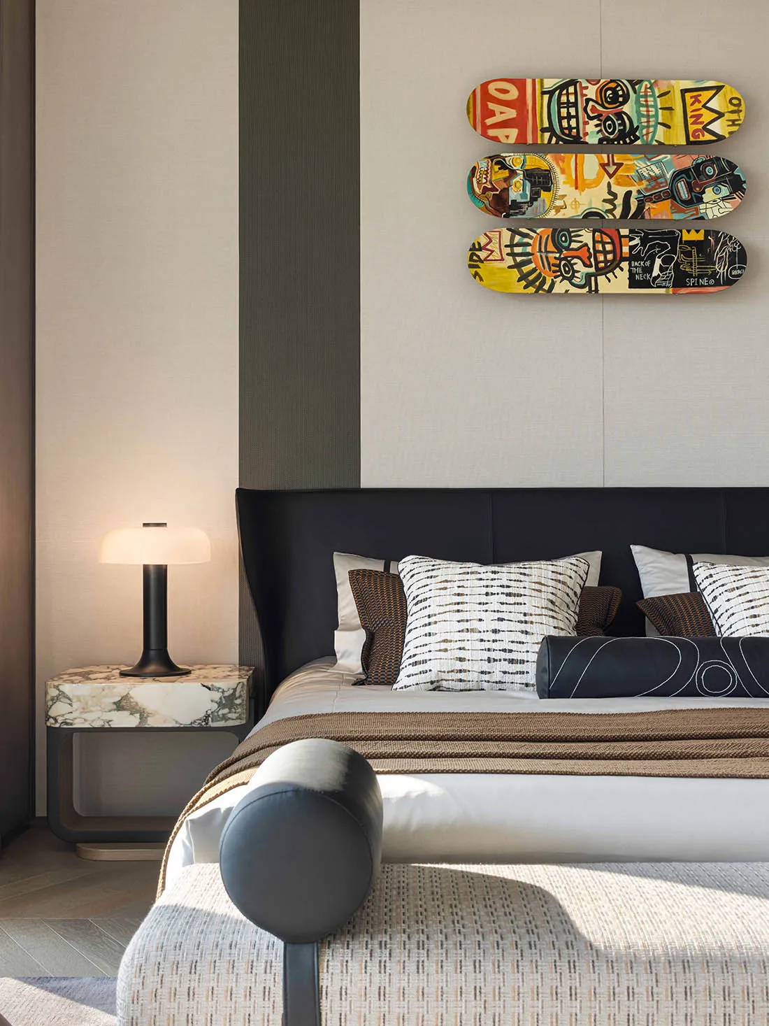 Cozy bedroom with a striped wall, a bed, a chair, and a skateboard painting on the wall