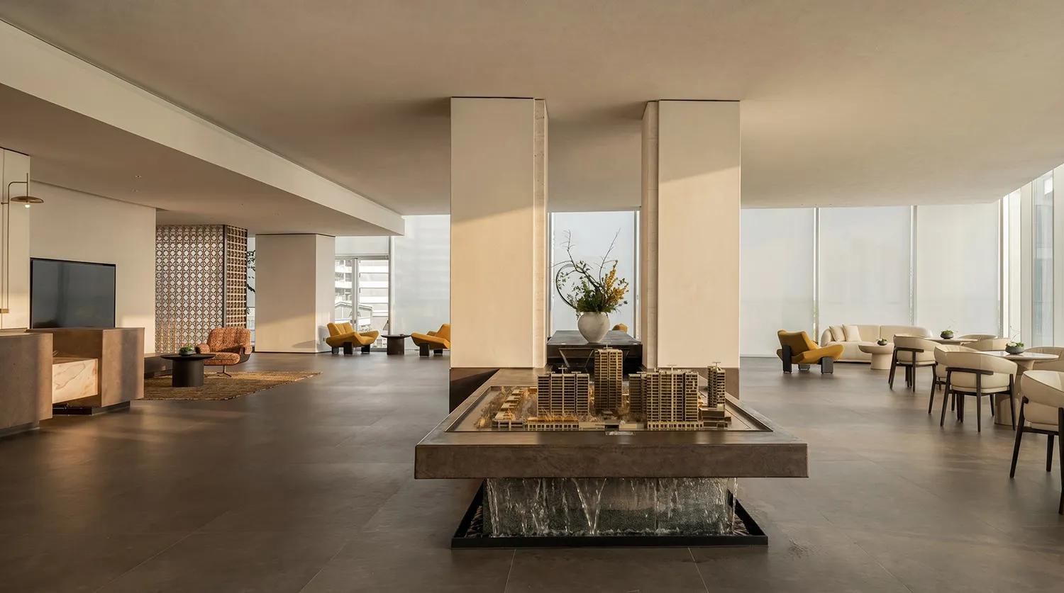 A modern living room with a large window, natural light, chairs, a couch, dining table, and vase, creating a comfortable and inviting atmosphere