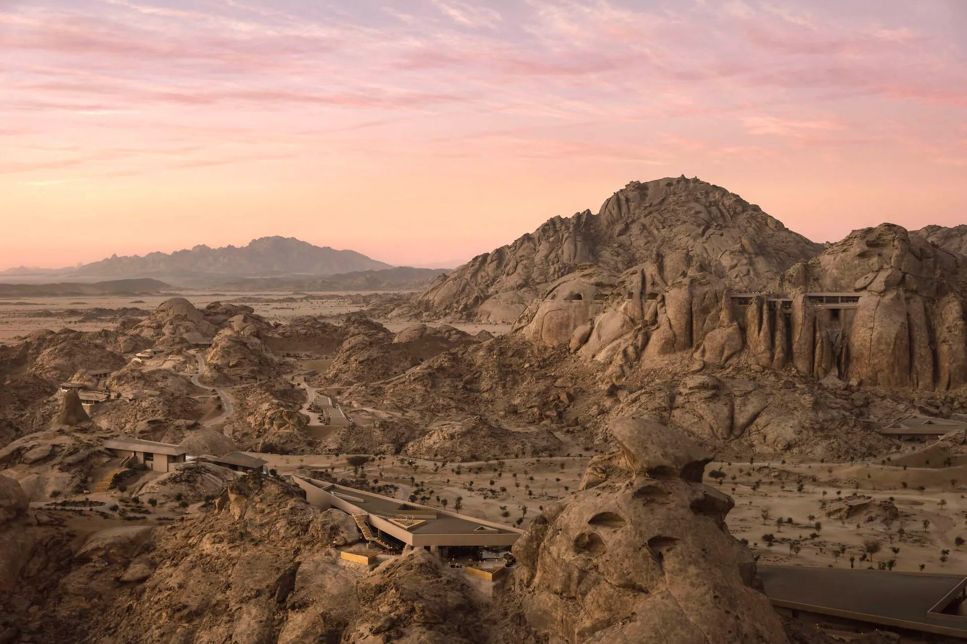 A serene natural landscape with a rocky terrain and a large rock formation, captured during sunset