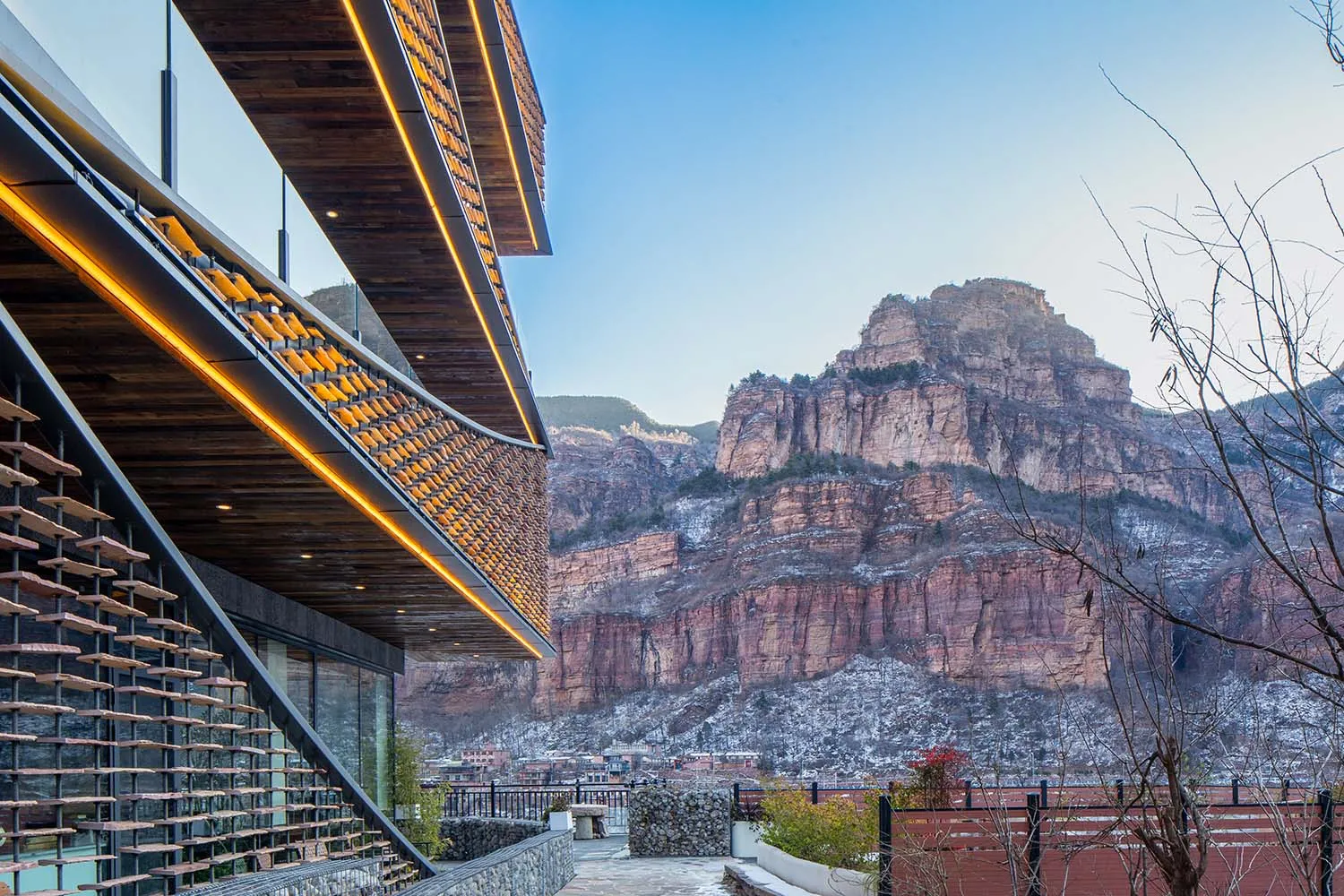 A modern house in a mountainous landscape with a large window and natural light