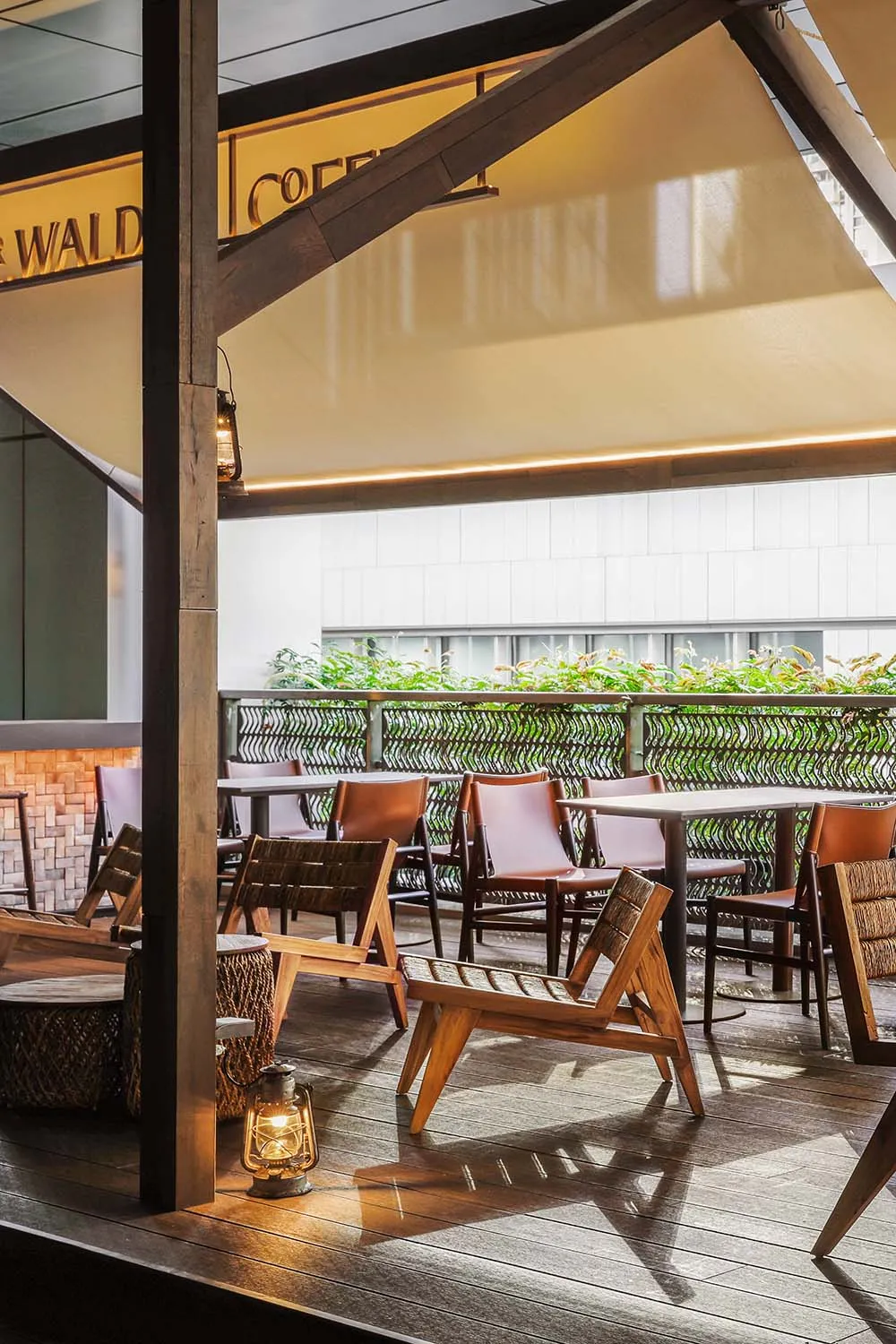 A well-lit outdoor dining area with a wooden table and chairs, surrounded by a bench, in a restaurant-like setting