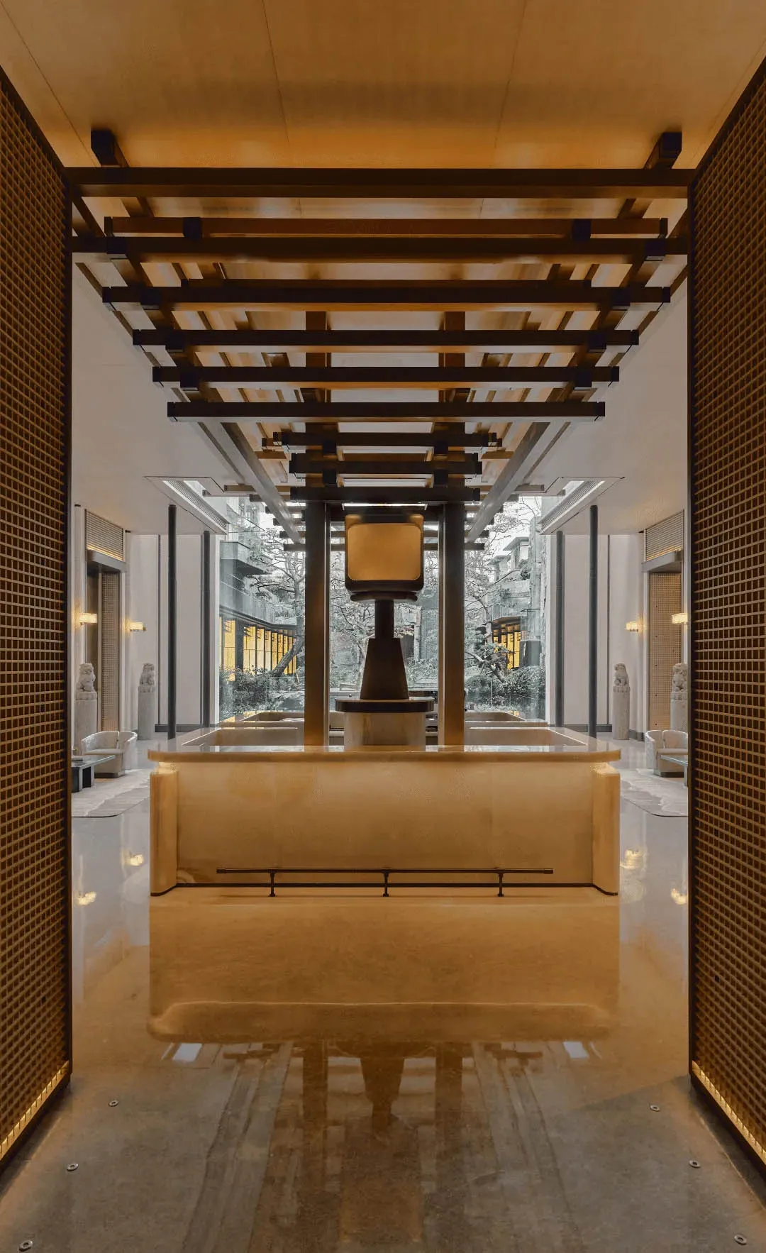 Modern lobby with a white marble countertop, chairs, and natural light from a large window