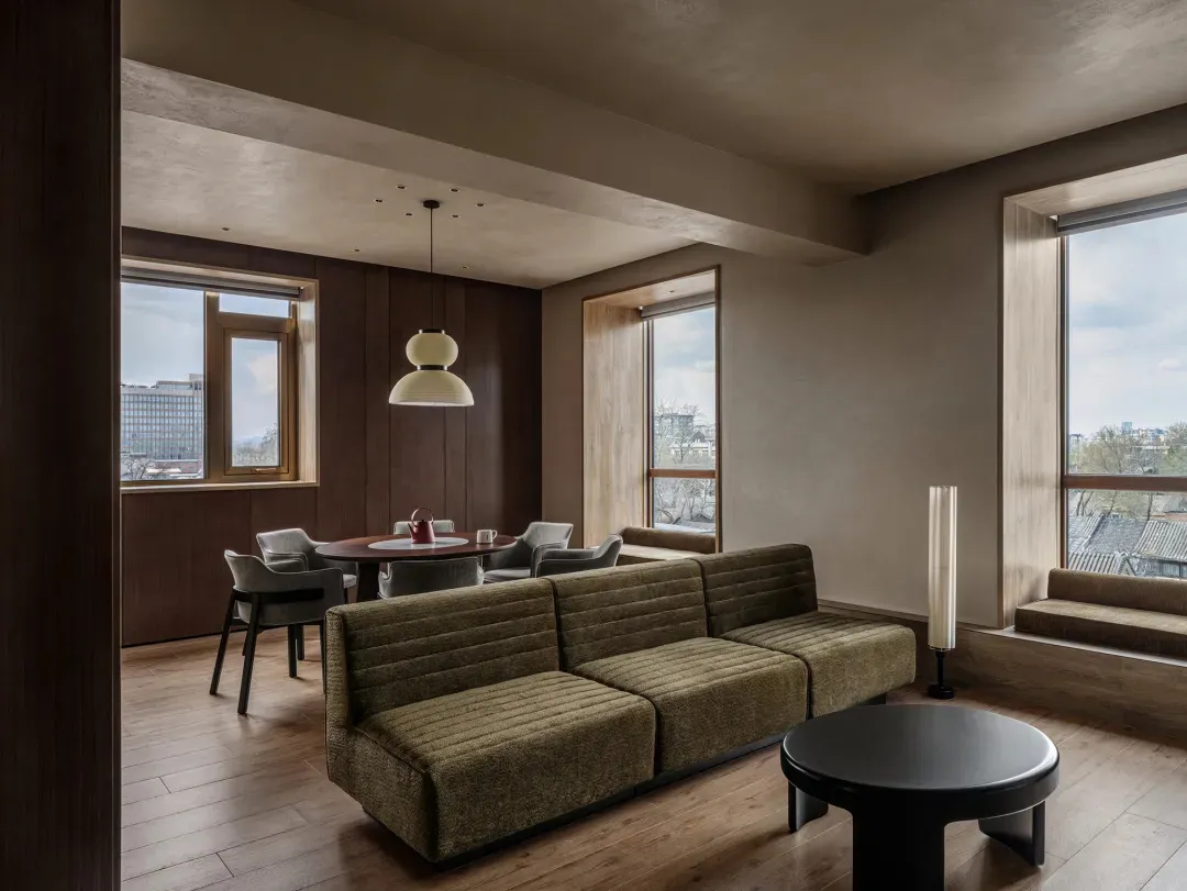 Comfortable living space with a couch in the center, a dining table on the left, and a lamp on the right, well-lit and inviting