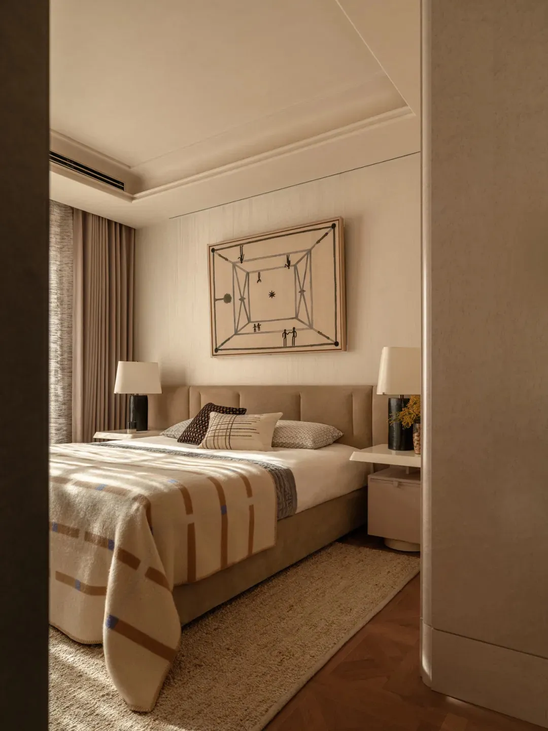 A well-lit bedroom with a bed, nightstand, and painting, featuring warm wood and fabric materials
