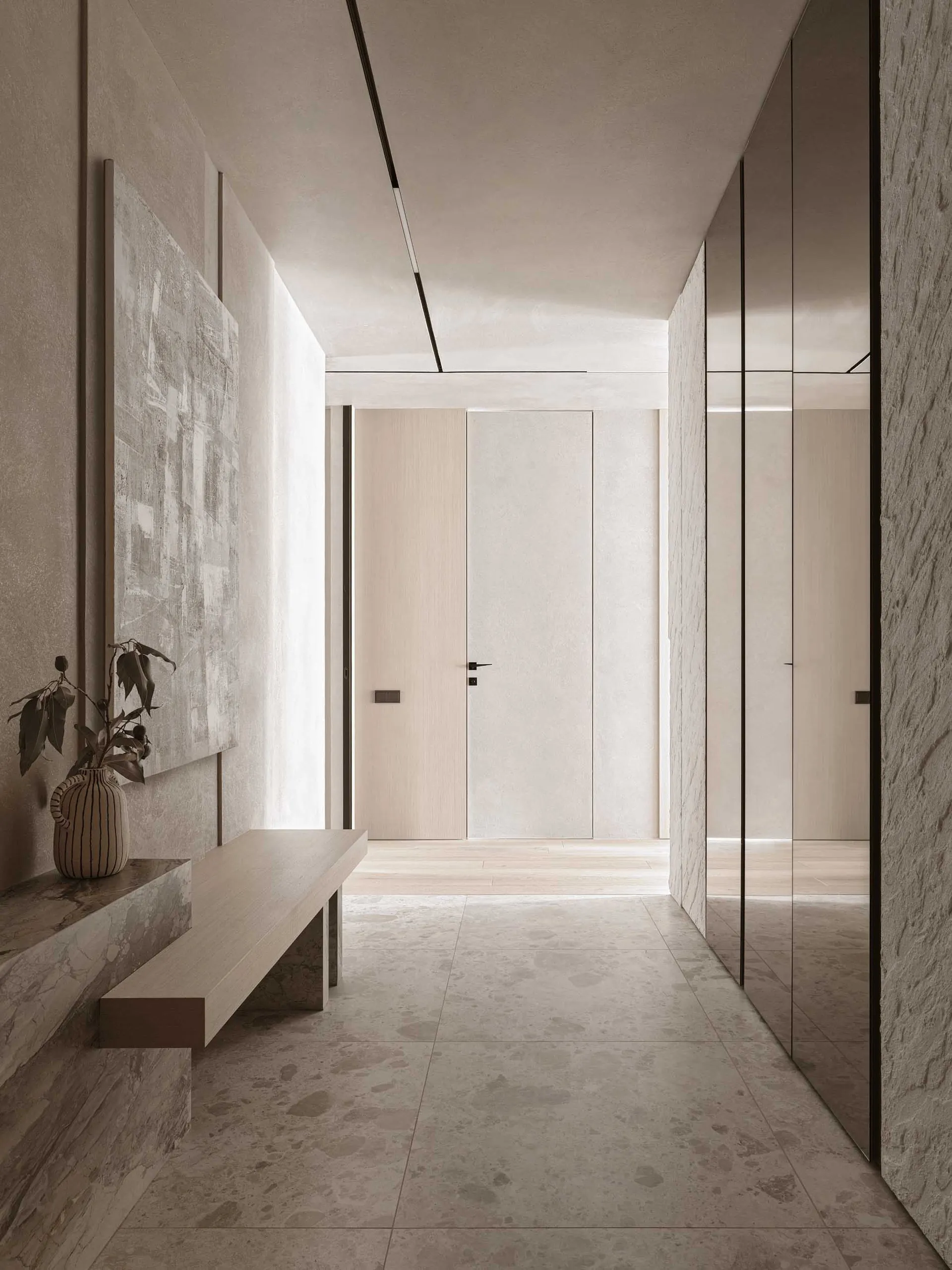 A well-lit modern hallway with a white color scheme, wood accents, and comfortable seating area with a bench