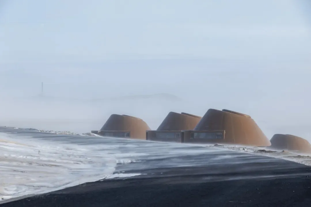 A row of small wooden cabins in a snowy landscape, creating a sense of community and shared living space