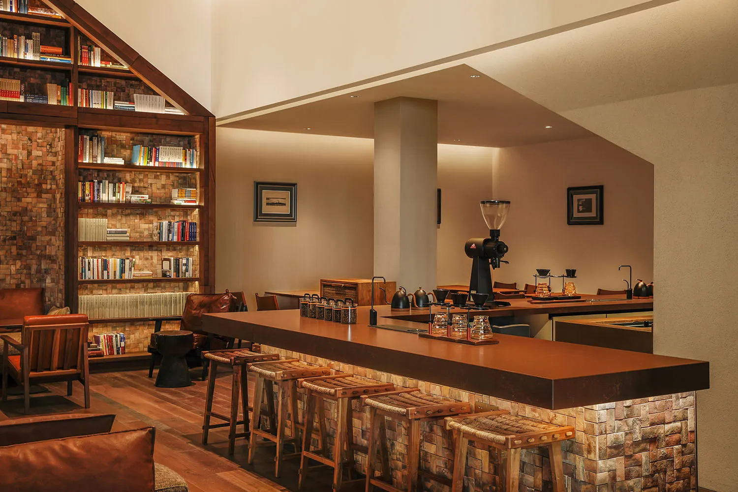 Cozy living space with a wooden floor, a wooden bar, and wooden stools, surrounded by books and a comfortable seating arrangement