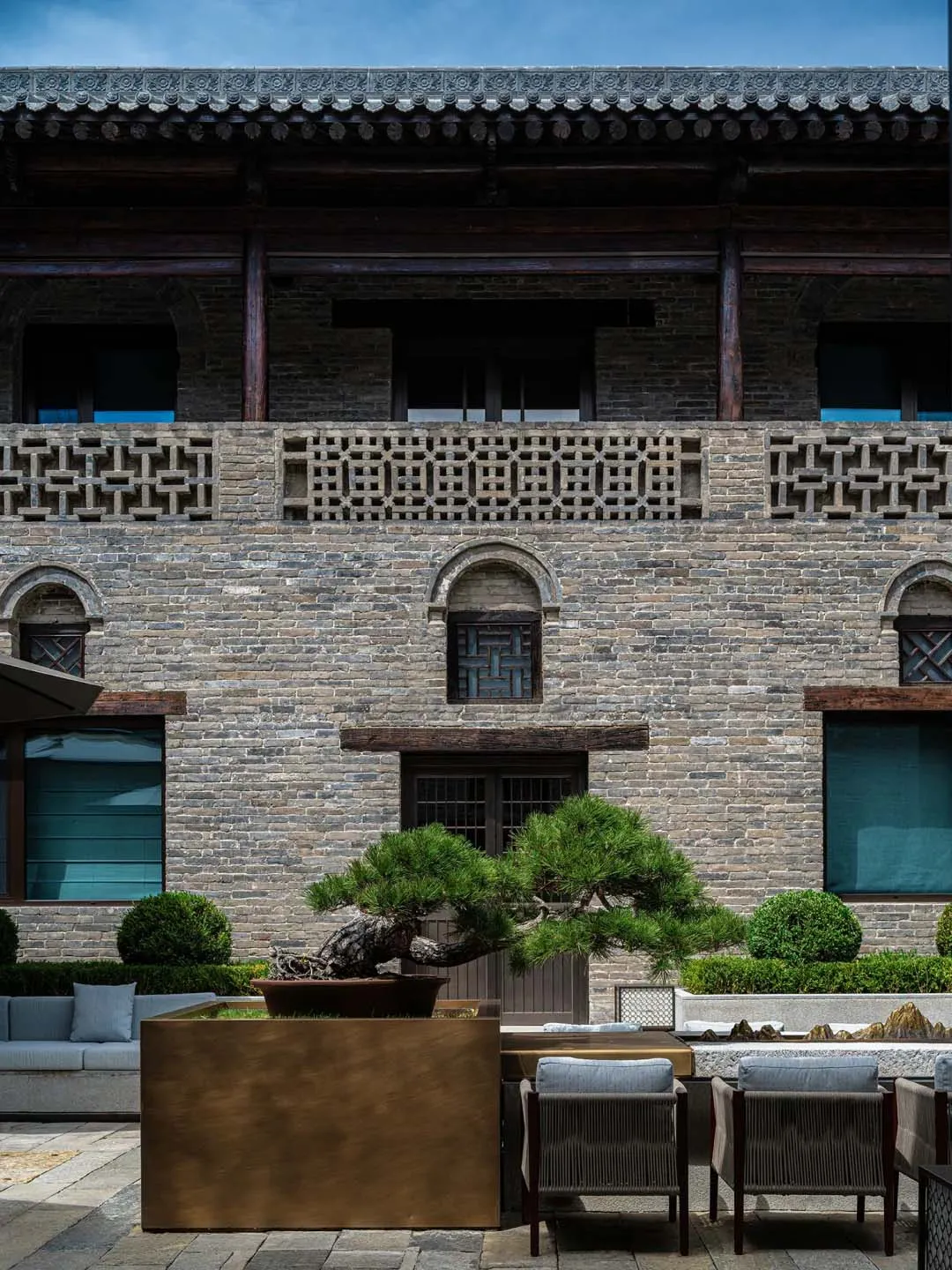 一座石磚建築，擁有窗戶，置於城市背景下