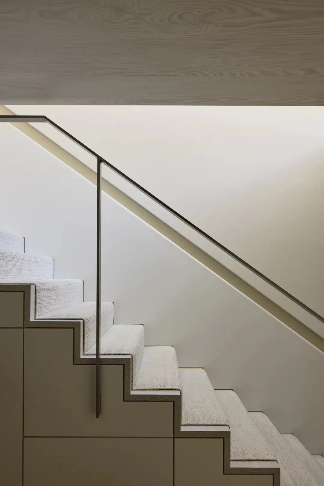 White staircase with a metal railing in a minimalist room with clean lines and a neutral color palette