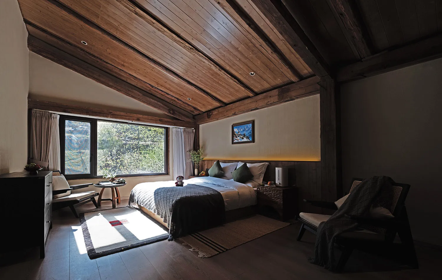 Cozy bedroom with a bed, chair, and window, featuring a wooden floor and ceiling, and well-lit with a bright atmosphere