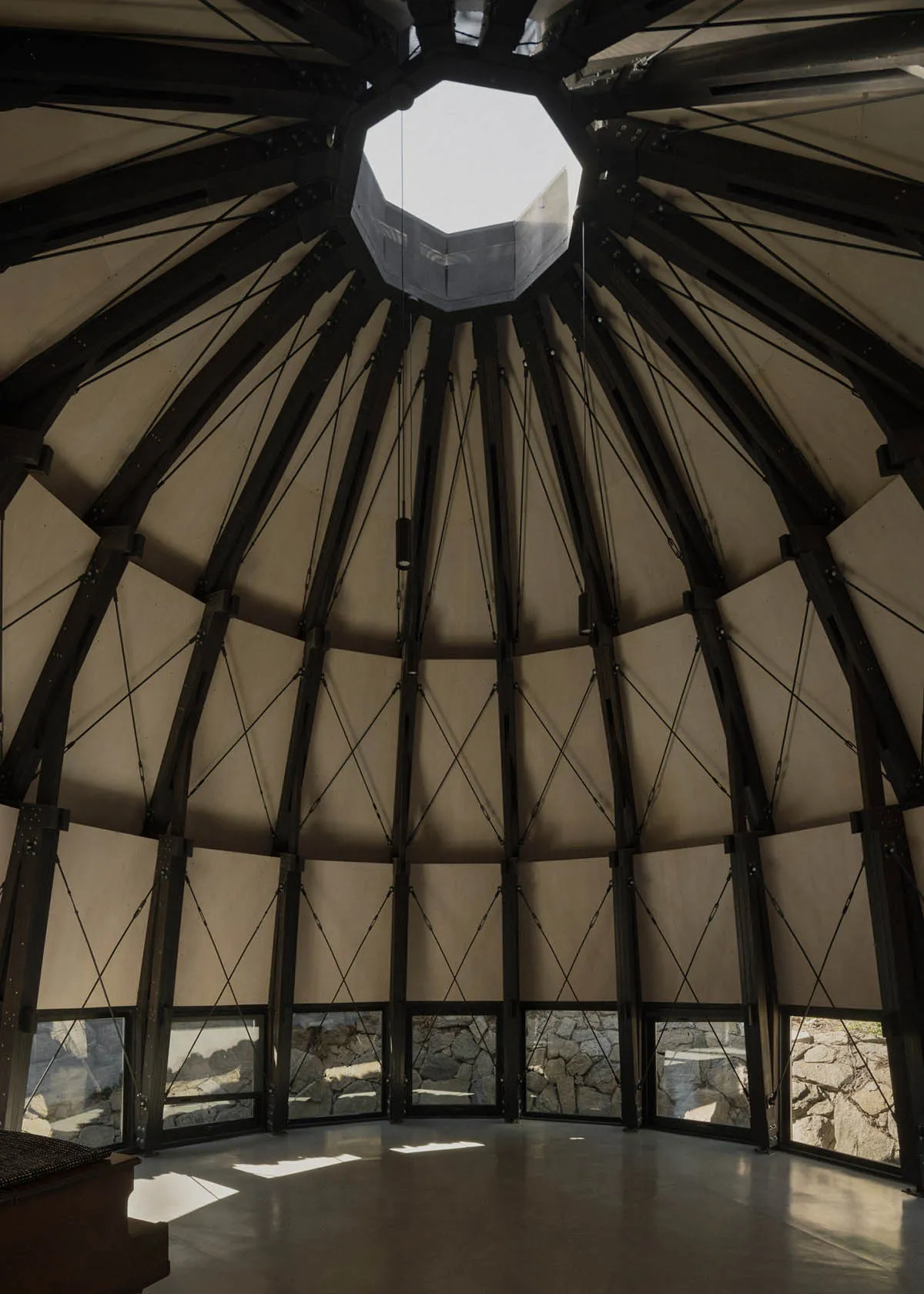 A large, airy room with a dome-shaped ceiling, wooden walls, and natural light, showcasing a modern and minimalist style