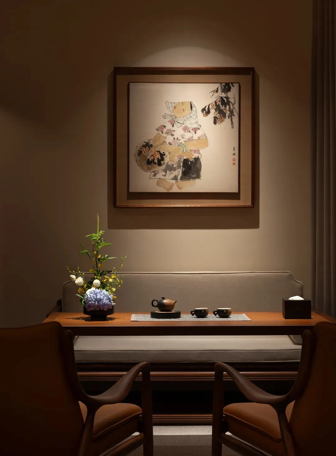 A cozy living room or dining area with a wooden table, chairs, couch, and chair, set with cups and a vase, creating a warm and inviting atmosphere