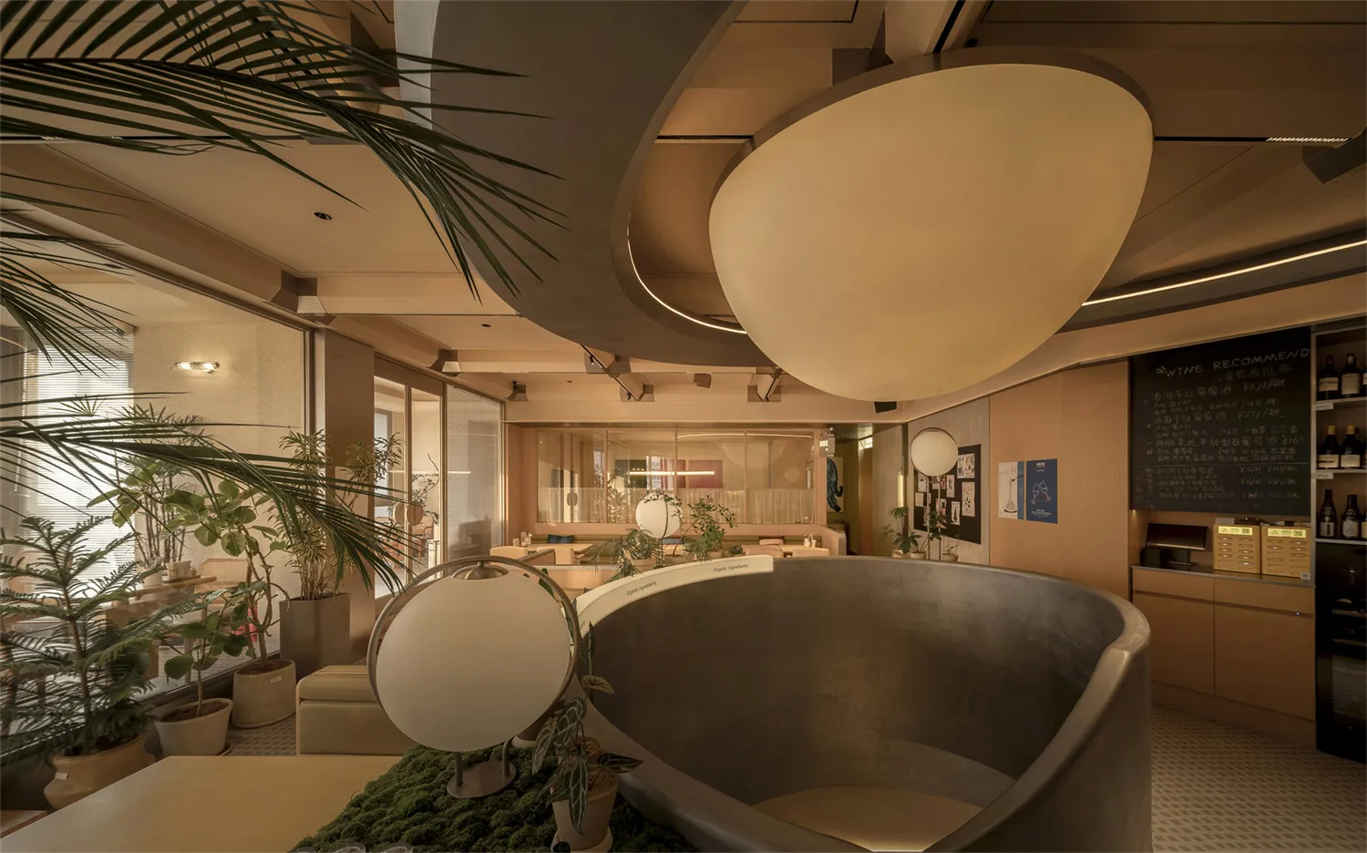 A large, open restaurant space with a high ceiling, circular design, and natural light, featuring wood furniture and decor