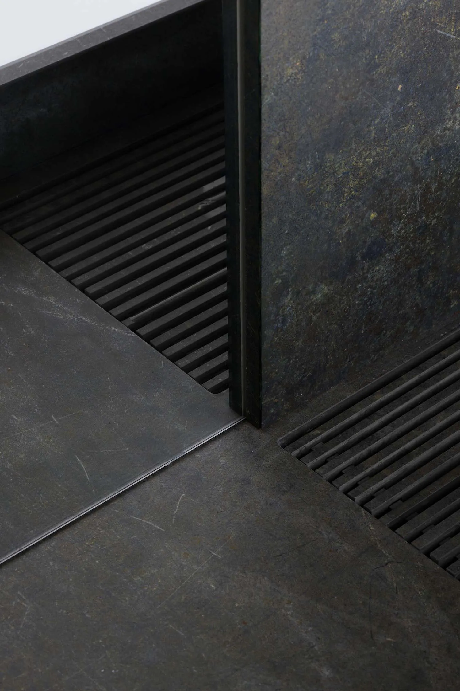A metal staircase with a metal door at the bottom, set in a commercial or industrial space