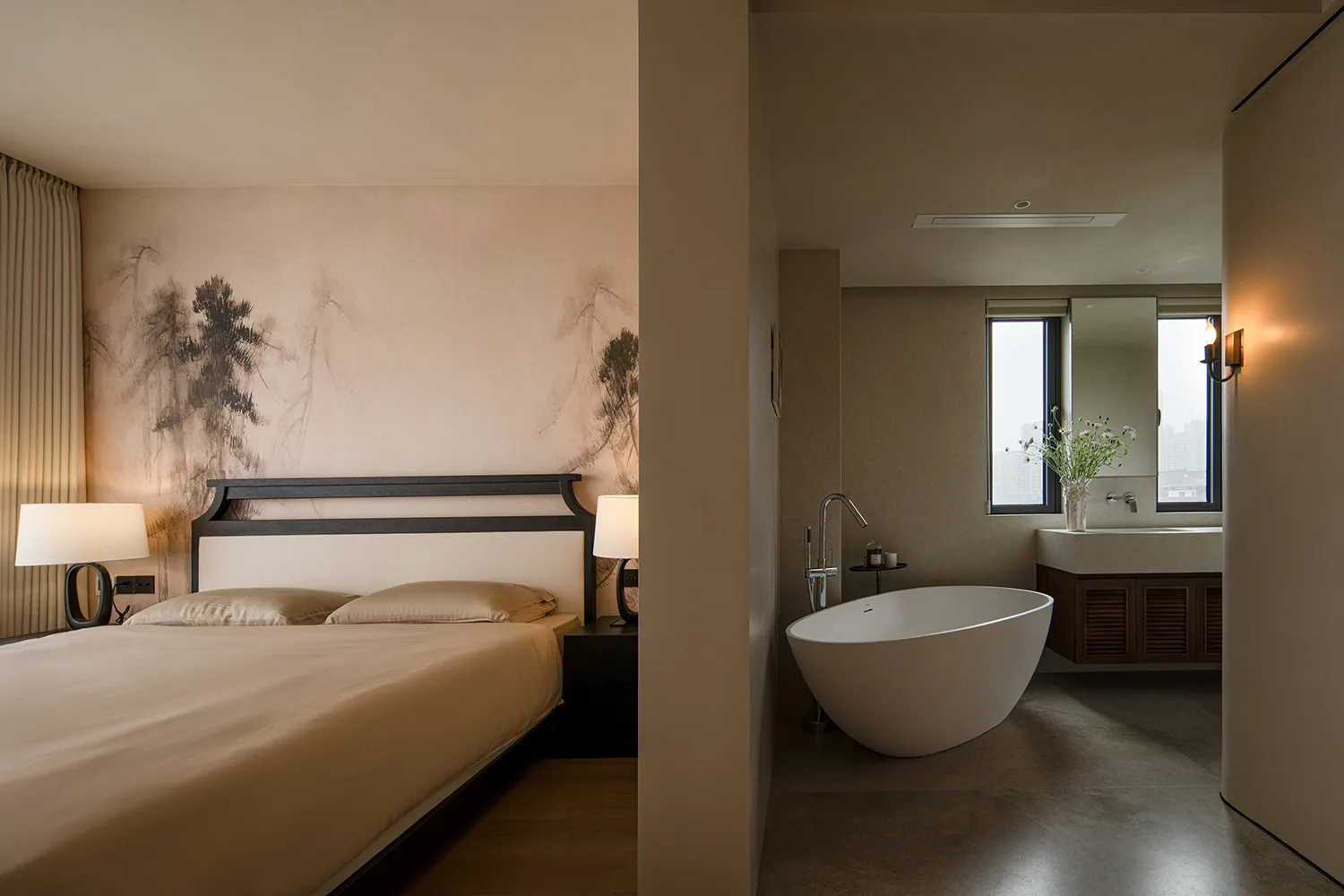 Bedroom with a brown color scheme, Asian-style paintings, a bed against the wall, and a bathtub near the window in a dimly lit space