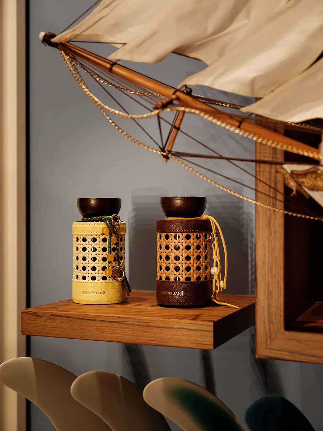 A modern living space with a wooden shelf displaying two decorative vases, against a blue wall with natural light creating a warm atmosphere
