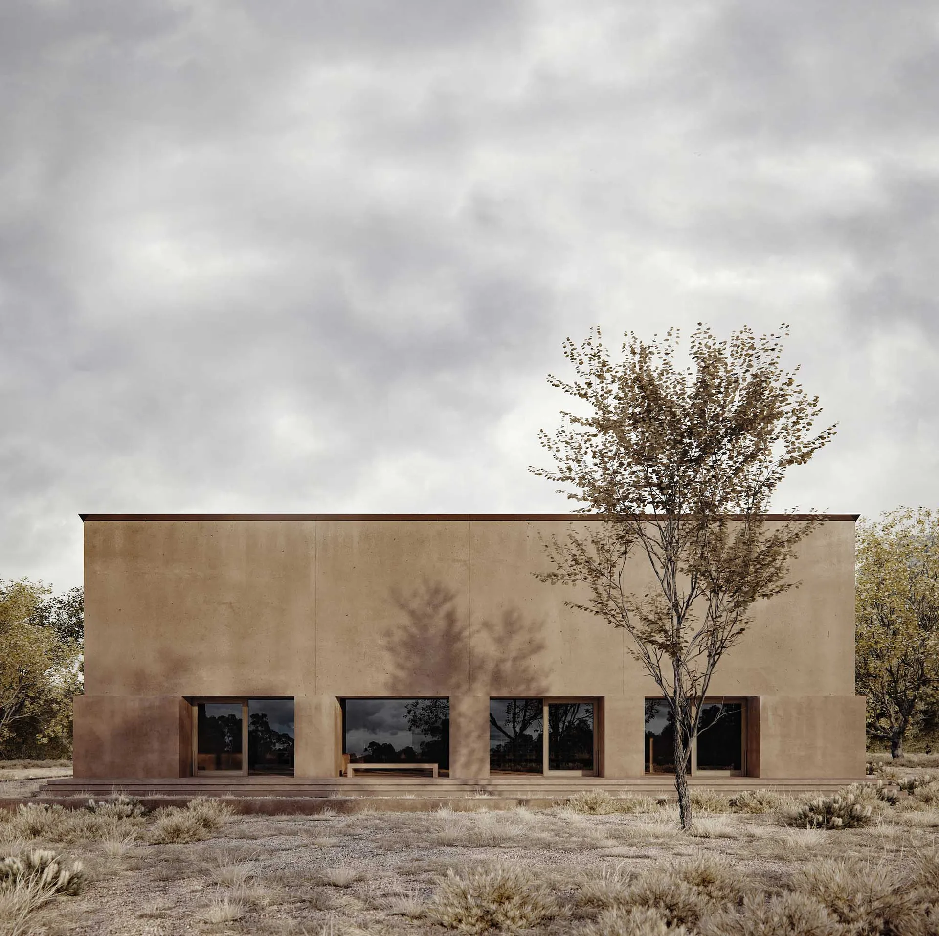 Photograph of a modern building with a brown concrete exterior, a large window, and a bench in a rural field with natural sunlight