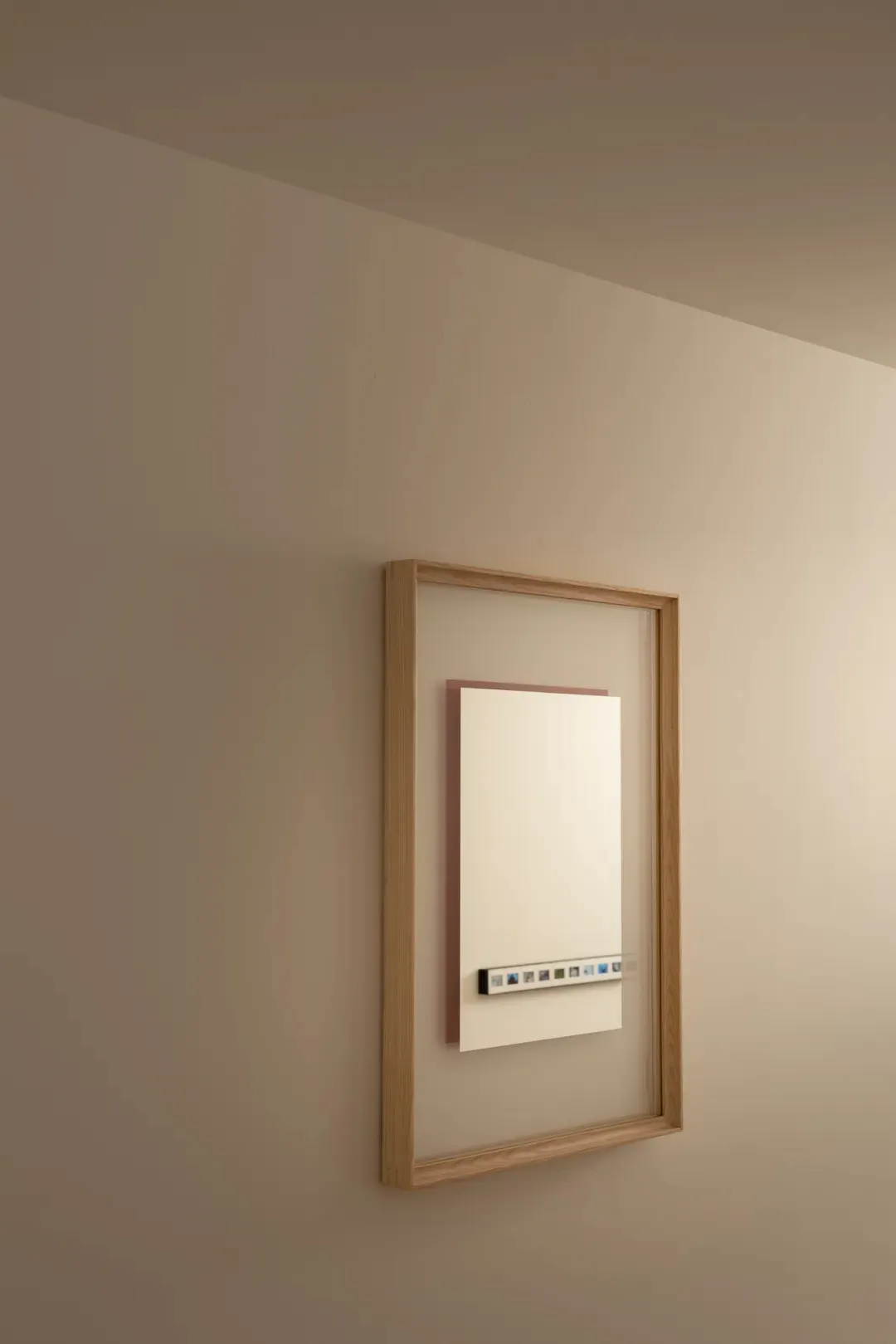 A modern residential bathroom with a white heater and mirror on the wall, mounted on a wooden frame, in a well-lit space with a clean and organized atmosphere