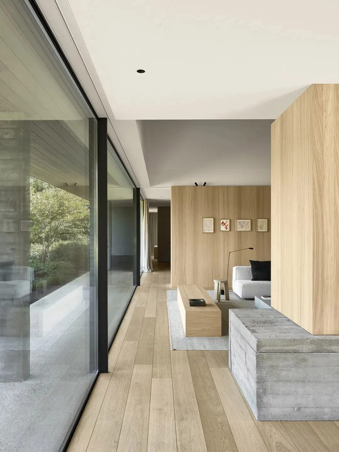 Open modern living space with a wooden floor, natural light, and various furniture and decorative items