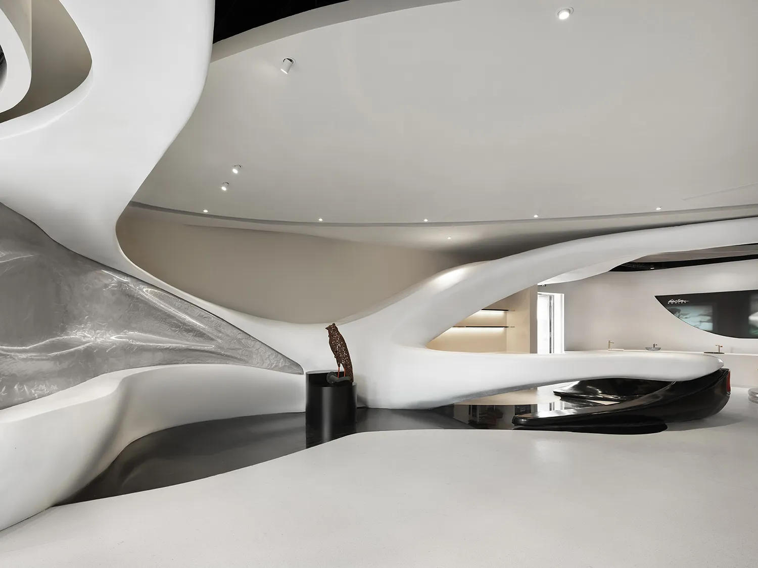 A modern, white, and curved building with a large, open interior and a clean and minimalist design