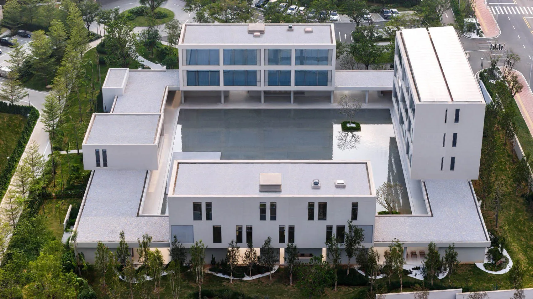 一座白色的大建築物，中央有游泳池，圍繞著一座甲板，在現代的建築風格中，具有豪華和高雅的感覺