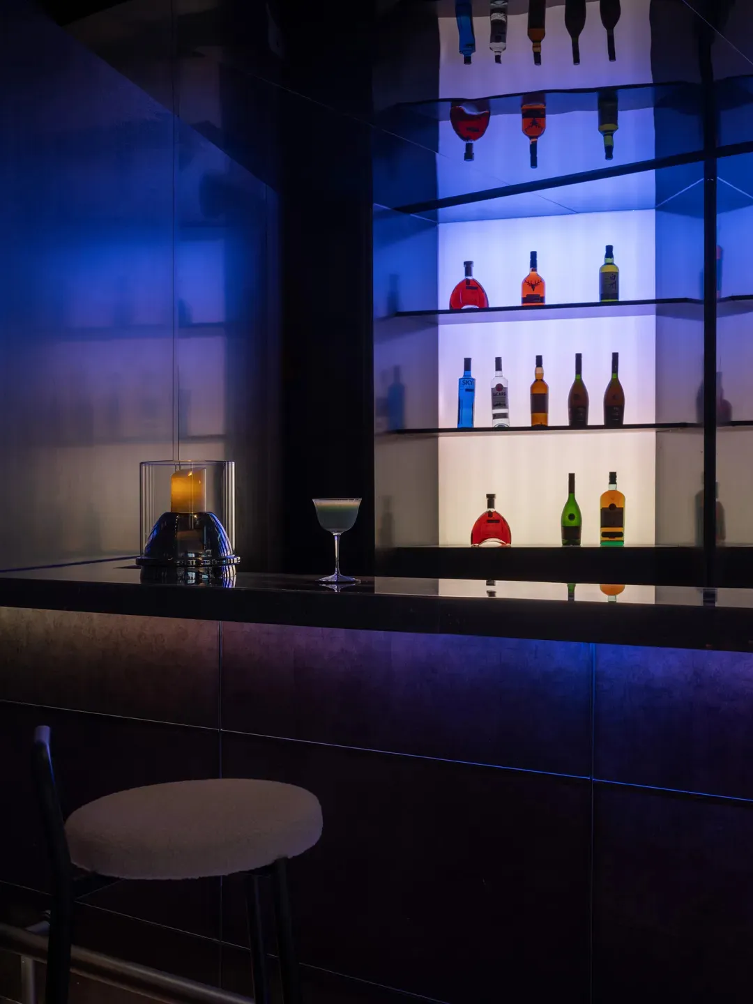 A bar area with a counter and various liquor bottles displayed on shelves, creating a cozy and inviting atmosphere
