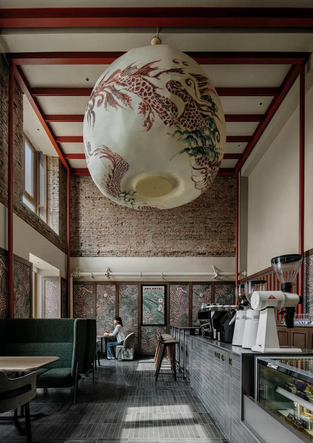 一間溫馨和溫暖的餐廳內部，brick牆、木頭家具和柔和的燈光，擁有高天花板的大空間，以及掛在牆上的藝術作品