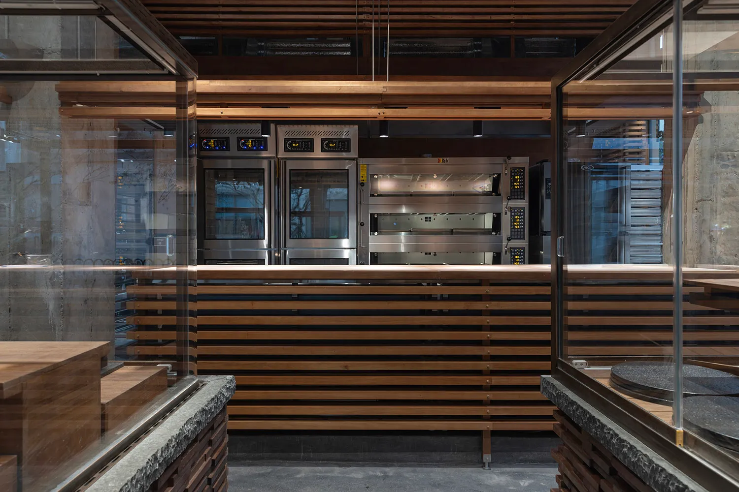 Bright and inviting kitchen with a large window, wood counter, and stainless steel oven, refrigerator, and appliances