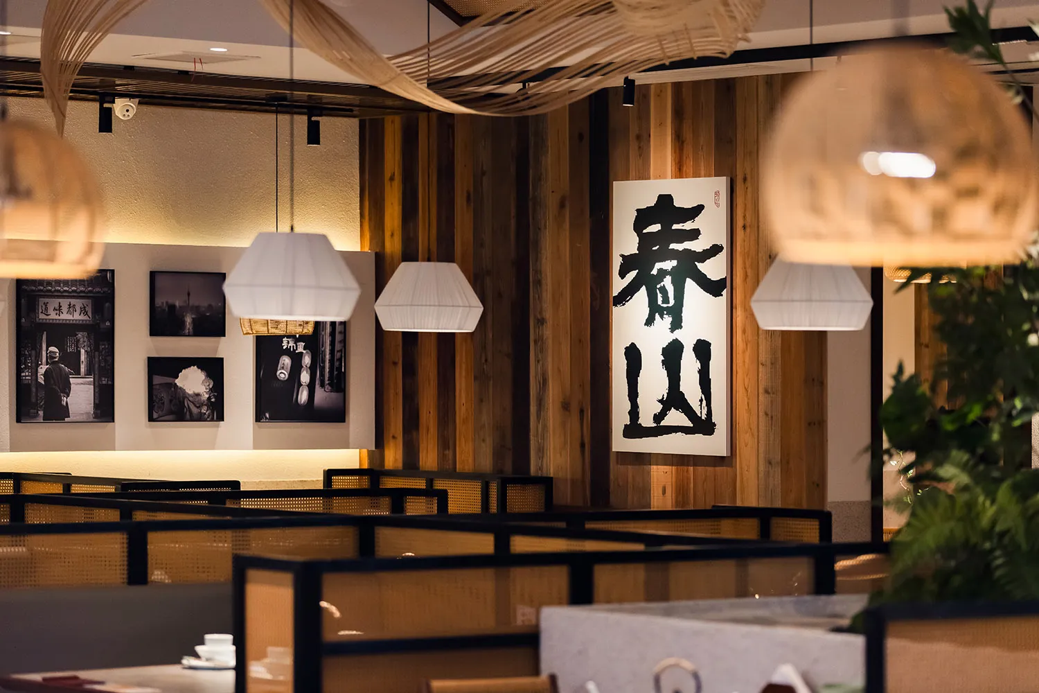 Cozy restaurant with a wooden floor, wall-mounted artwork, and soft lighting