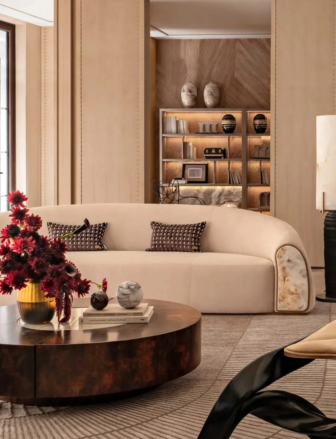 Comfortable living space with a large white couch, coffee table, fireplace, and decorative items, well-lit and inviting