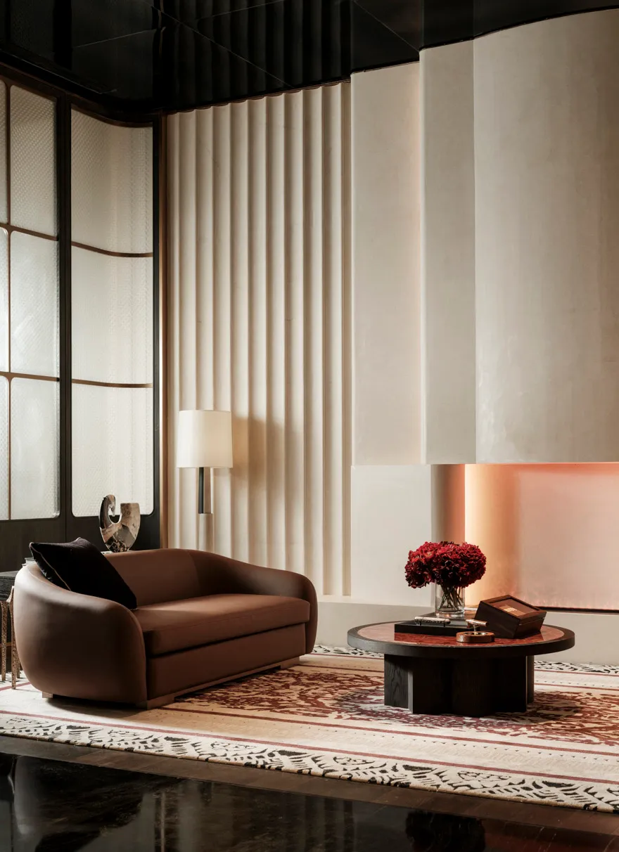 Cozy living room with a brown couch and chair, a fireplace, and a large window providing natural light