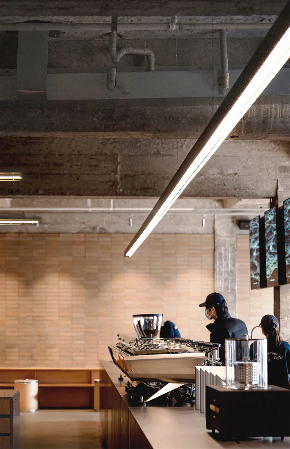 Cozy restaurant interior with a modern bar, brick walls, and a concrete floor, featuring a TV, chair, and dining table