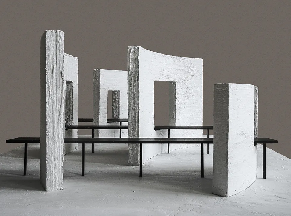 一座現代的石牆建築，具有混凝土地板，展示一座大型石牆和石凳，透過陽光獲得自然光線照射