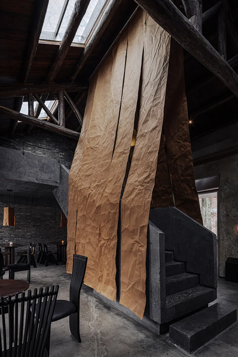 Cozy restaurant dining space with a stone staircase, wooden floor, and dim lighting