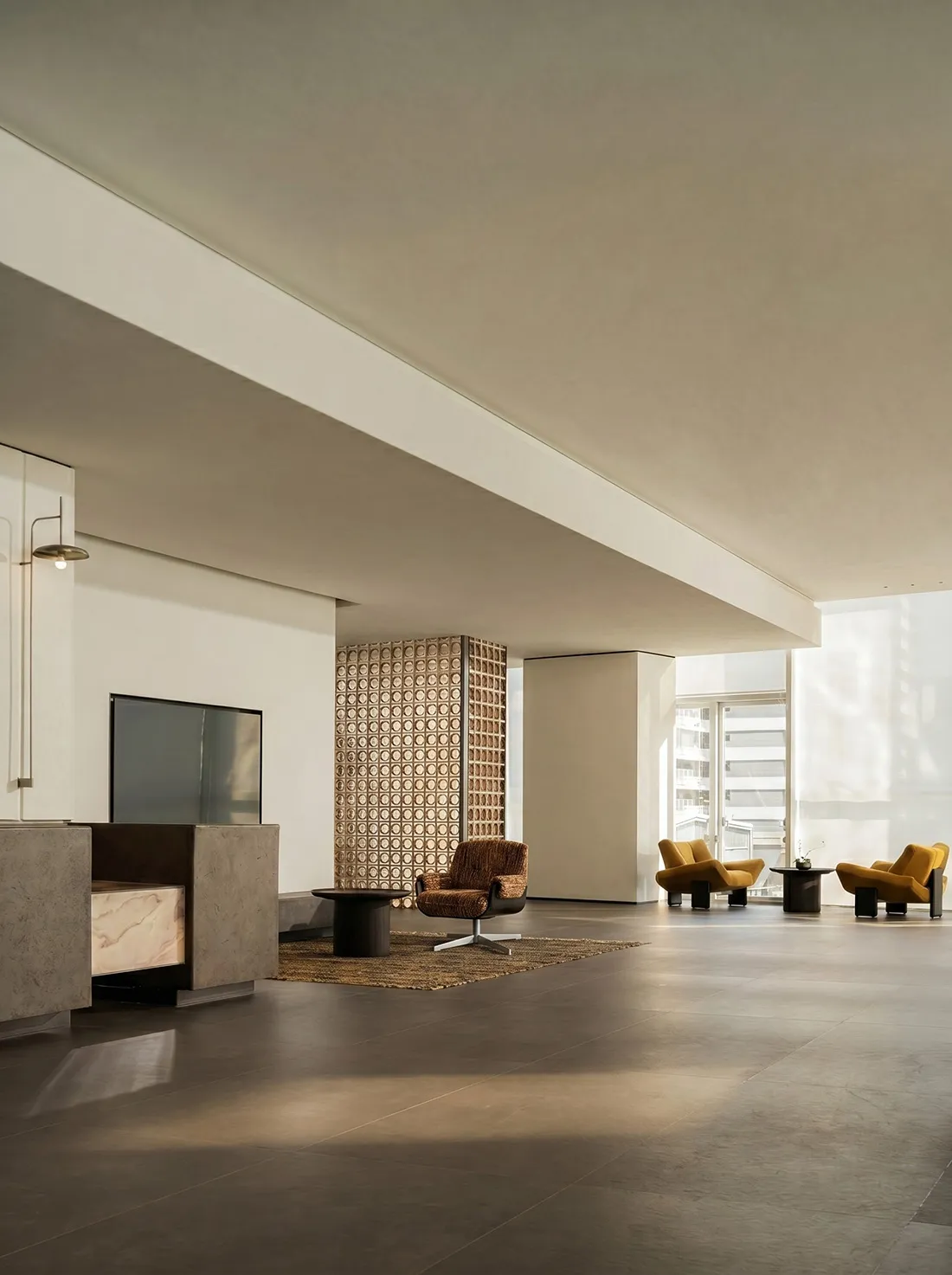 A modern living room with a couch, chair, and TV, decorated with a rug and featuring bright, natural lighting