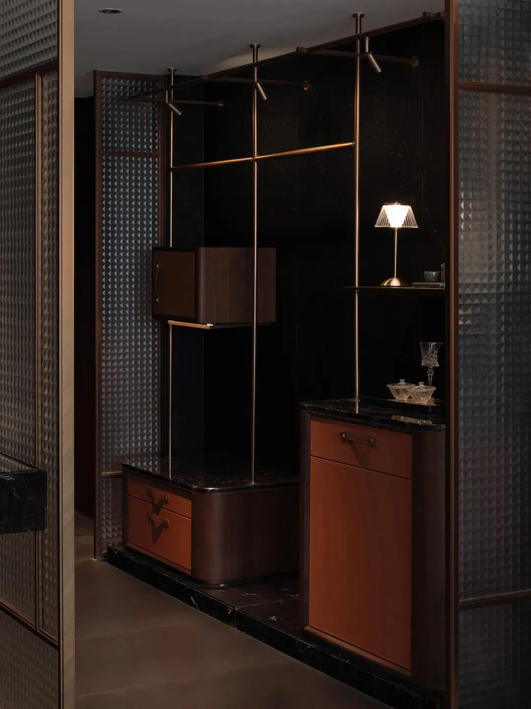 A modern bedroom with a brown color scheme, featuring a brown cabinet, dresser, and table, with a lamp and vase on the table, and a bed in the background