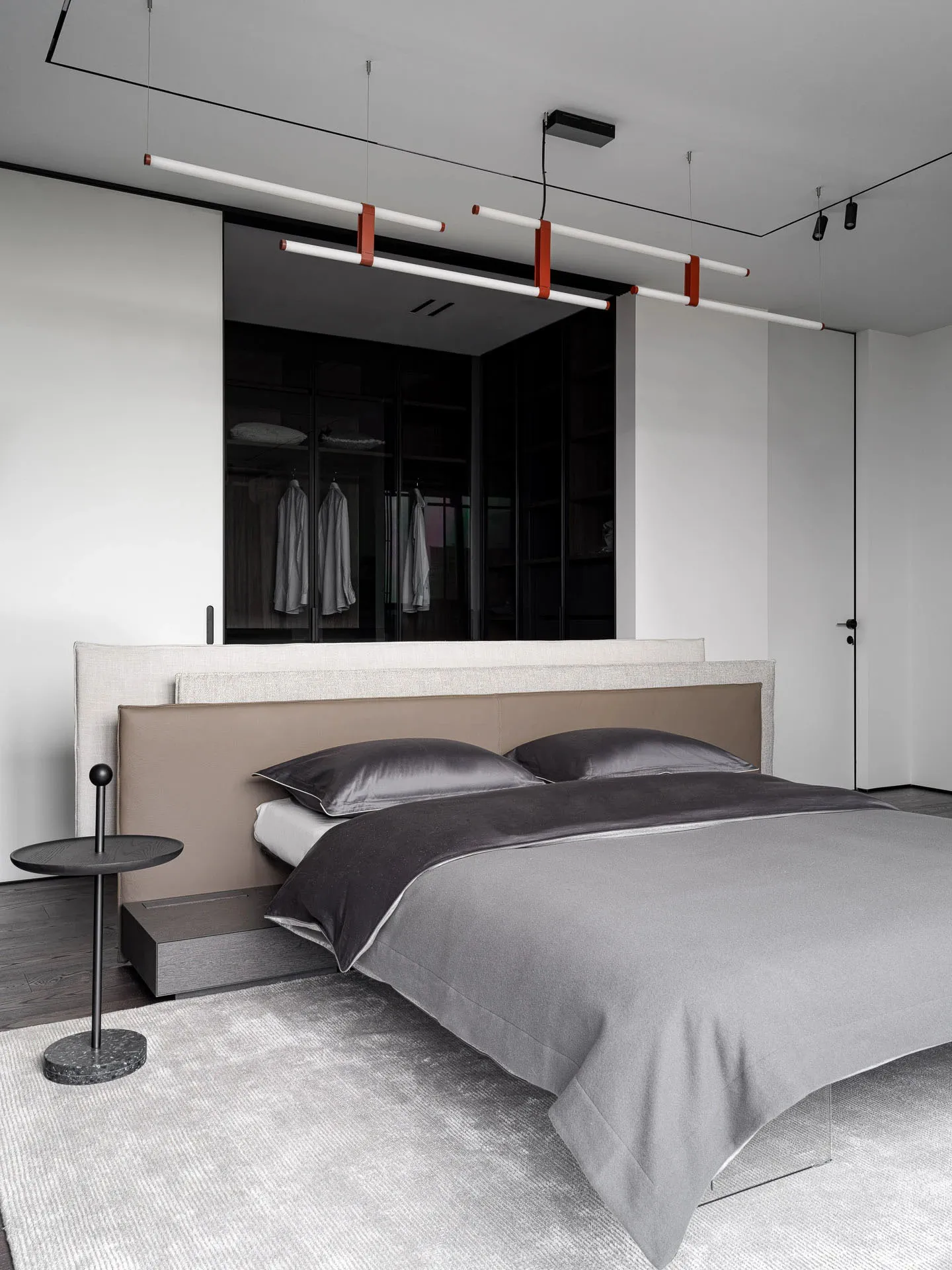 Cozy bedroom with a bed, nightstand, and dresser in a grey color scheme, with dim lighting and wood and fabric materials