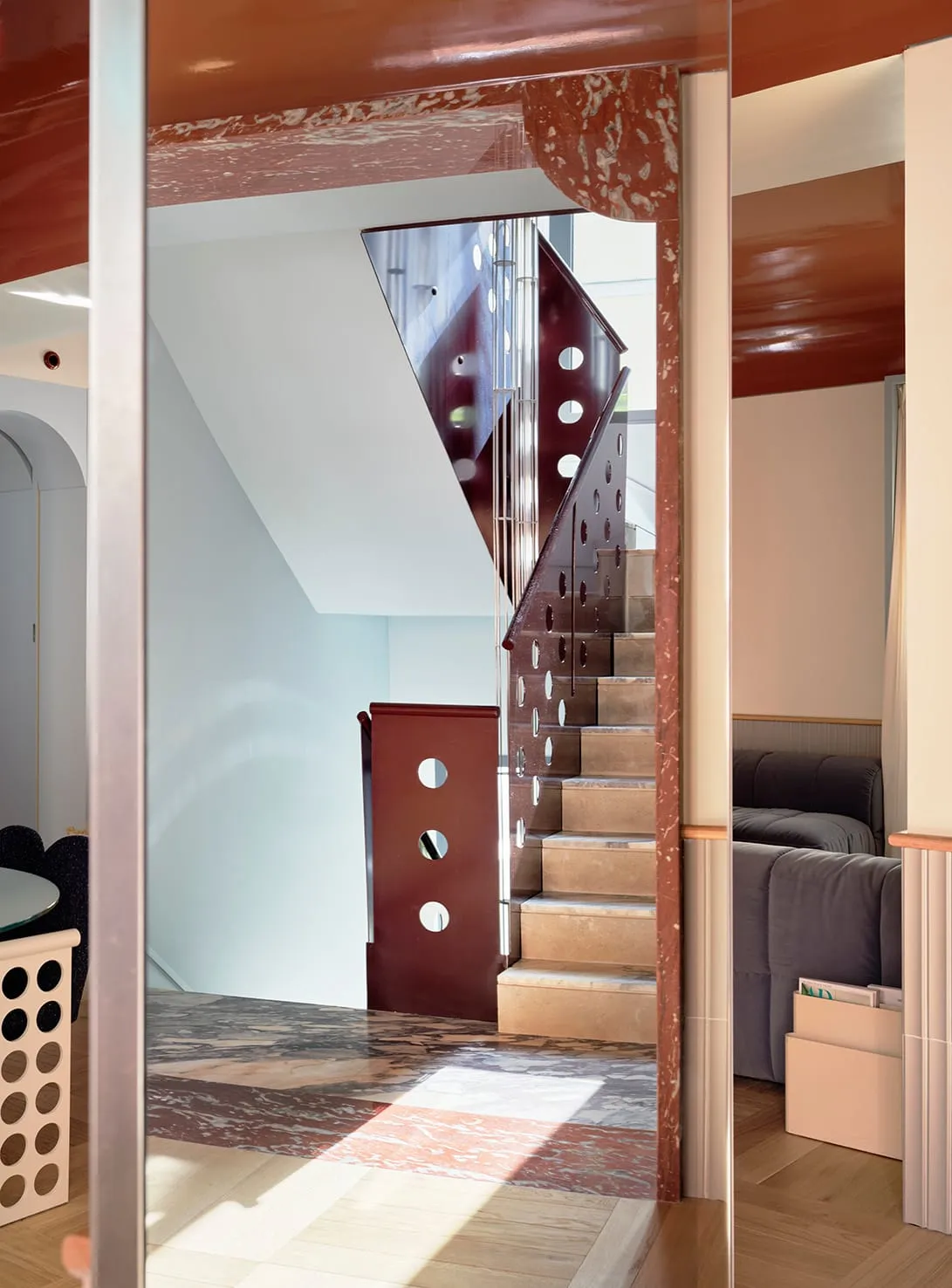 A dimly lit living room with a wooden staircase and metal railing, creating a cozy atmosphere