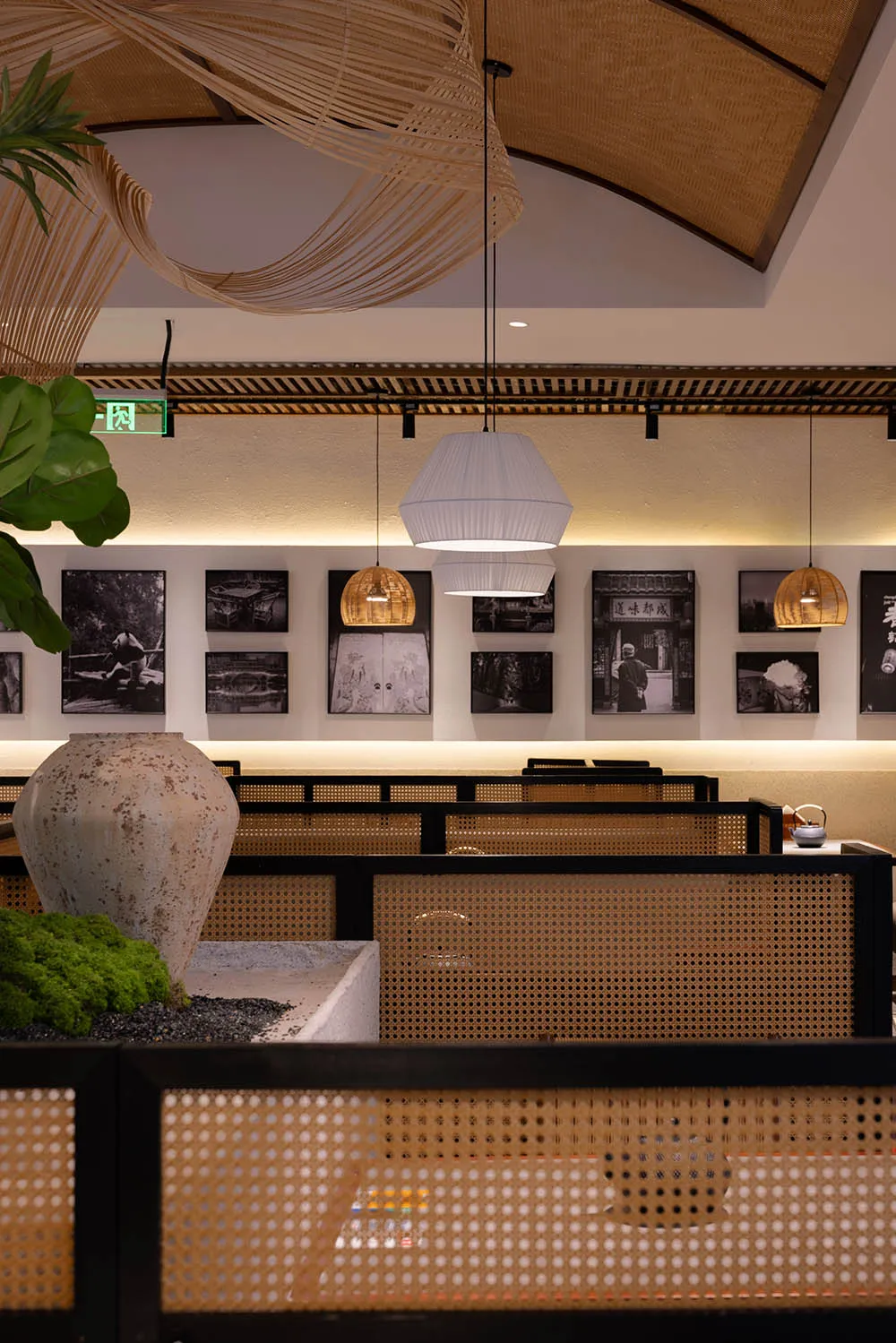 A modern restaurant interior with tables, chairs, artworks, and hanging lights creating a warm and inviting atmosphere