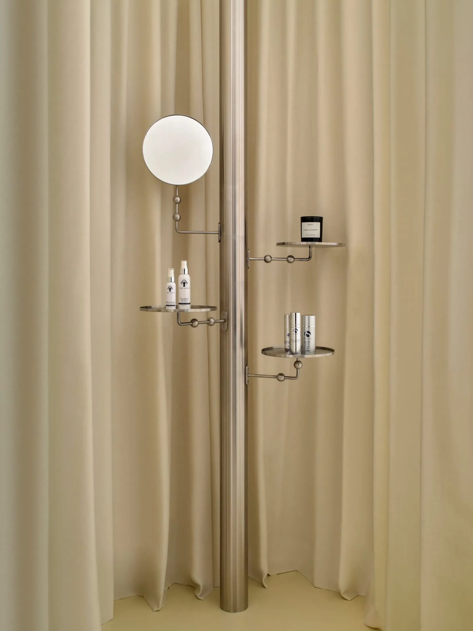 Modern bathroom with a wall-mounted mirror, shelf, and shower curtain, featuring dim lighting and a focus on functionality