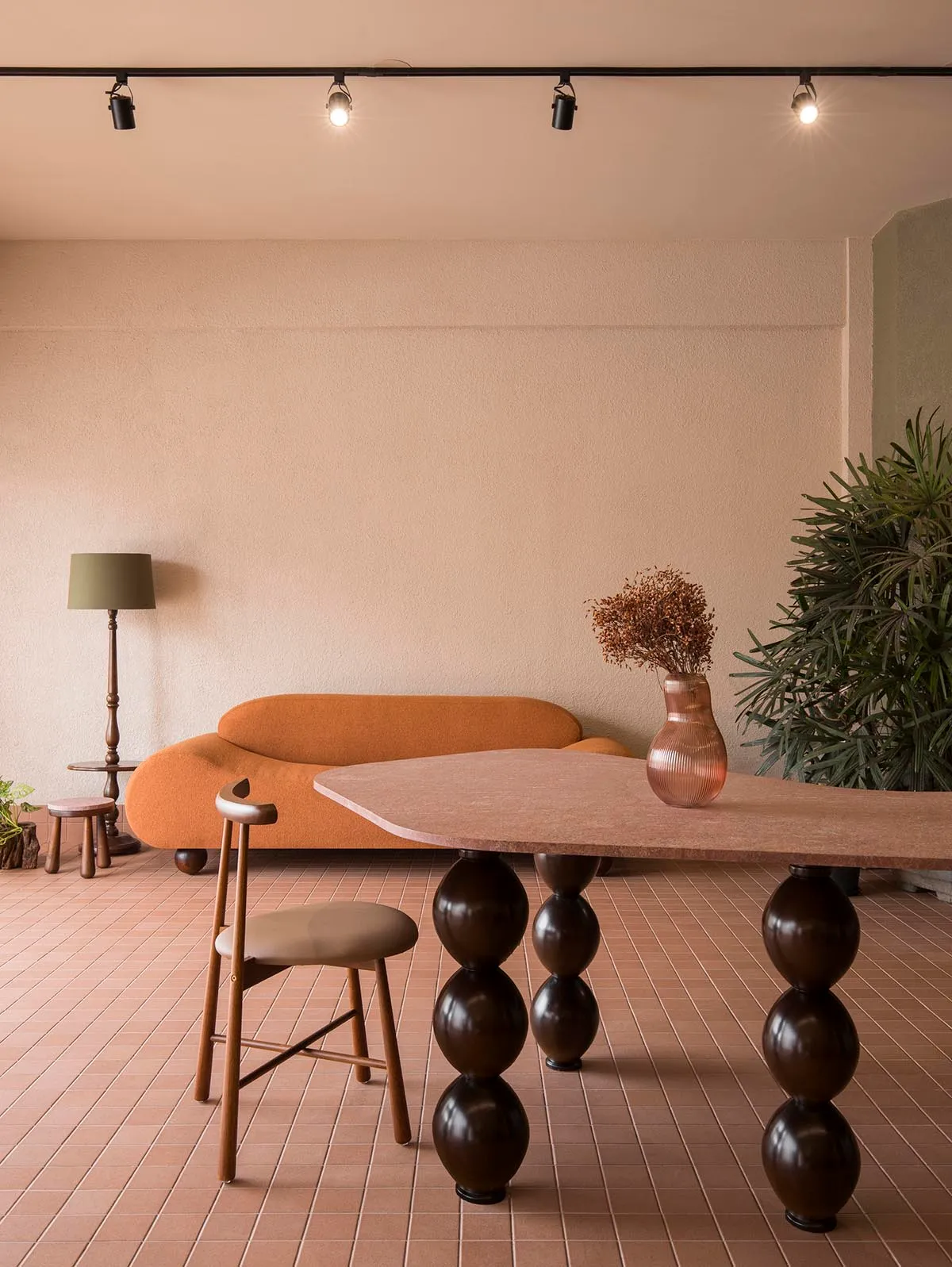 Cozy living room with a wooden floor, a couch, a chair, and a dining table, featuring a mix of natural and artificial lighting
