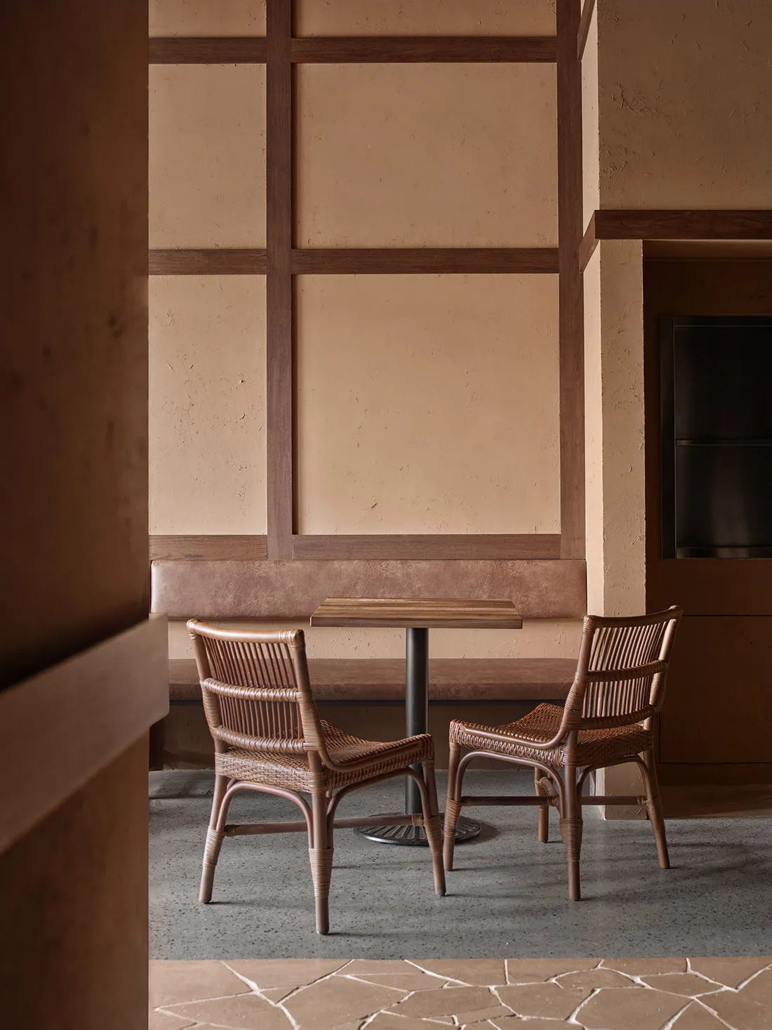 A warm and inviting dining area with a table surrounded by chairs and a bench, well-lit by natural light through the windows
