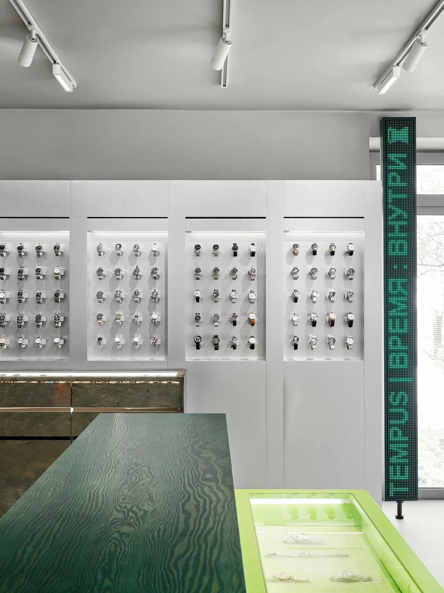 A well-lit store display featuring a collection of watches on a table and shelves, with a sophisticated and elegant atmosphere
