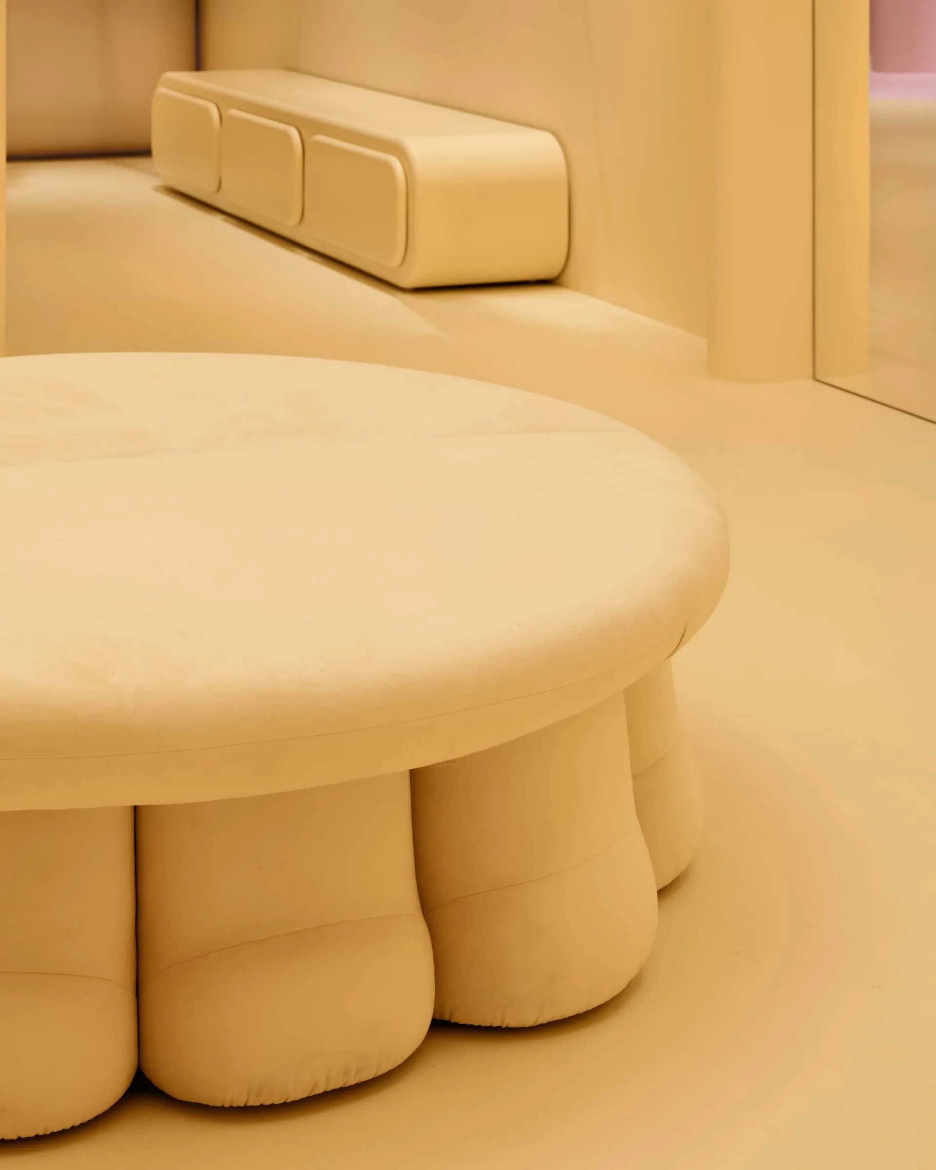 Cozy living area with a yellow color scheme, a white couch, and a white bench, featuring soft and warm lighting
