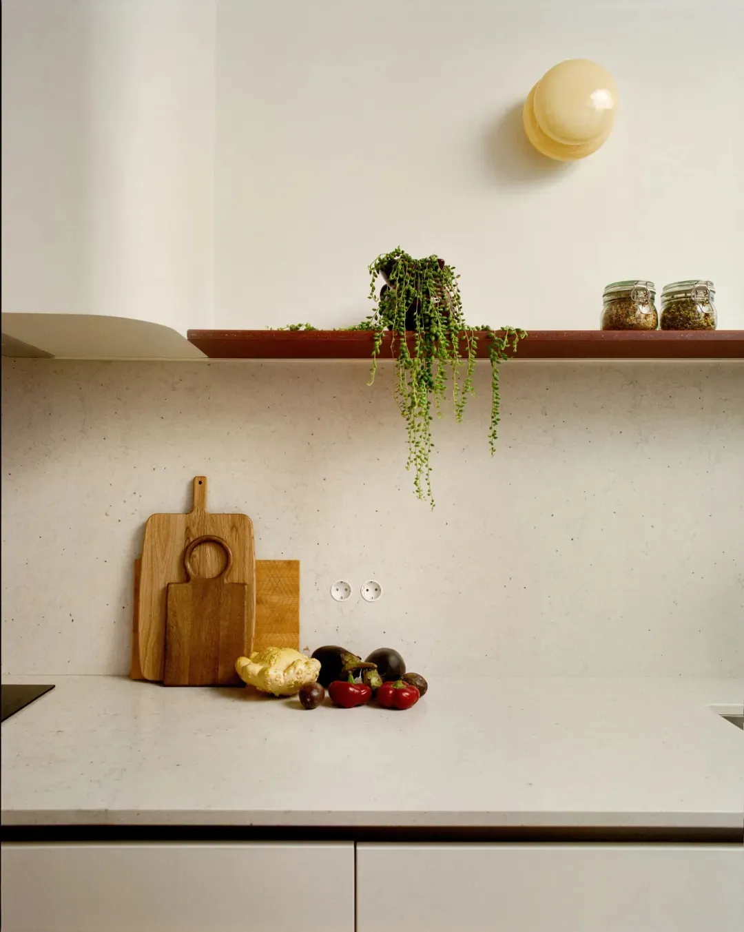 A well-lit kitchen counter displaying a variety of fresh fruits and vegetables on a marble surface