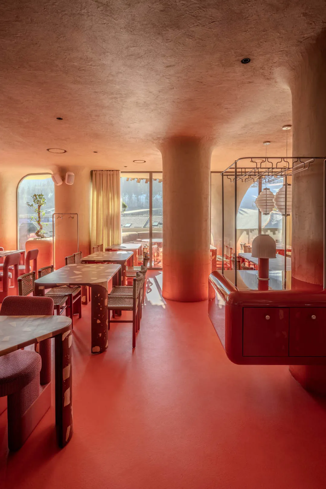Warm and inviting restaurant with red walls, red carpet, and dim lighting, featuring a dining area, bar, and red furniture